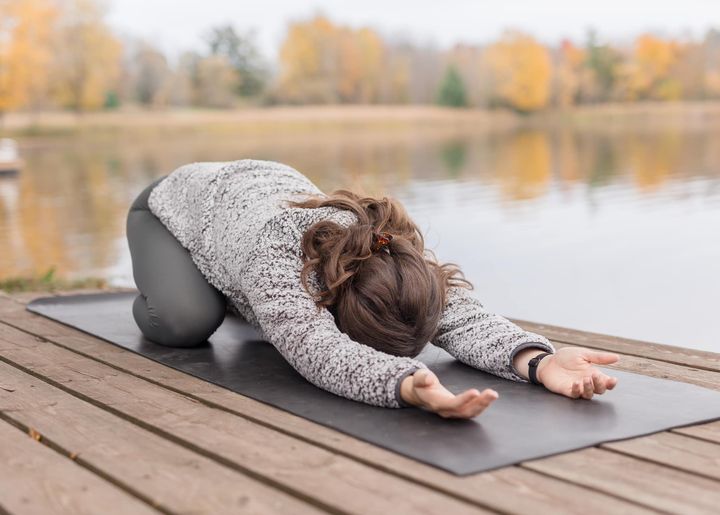 Women doing a yoga pose on a dock